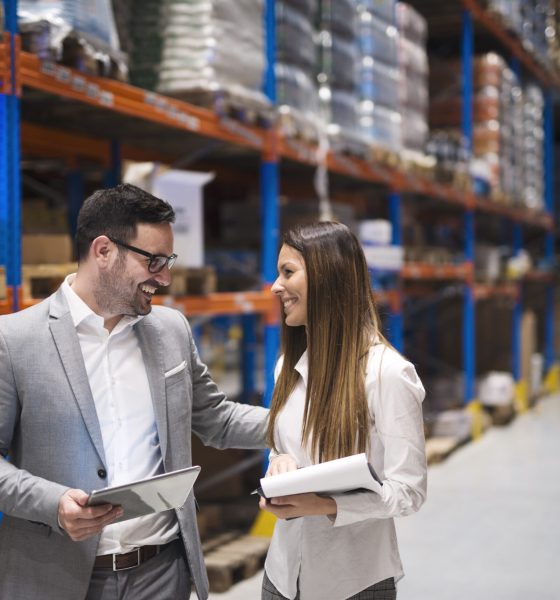 Warehouse managers visiting large warehouse checking distribution.